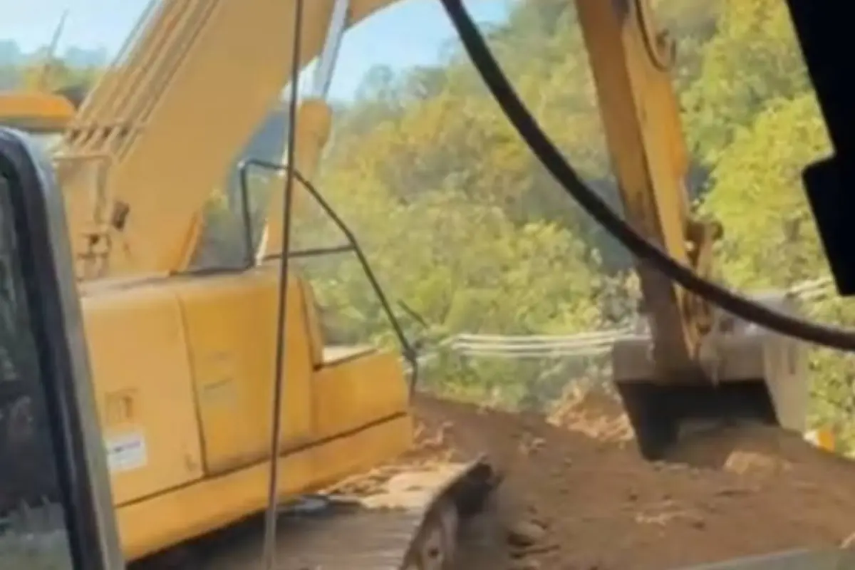 Excavator completing earthwork on sloped terrain